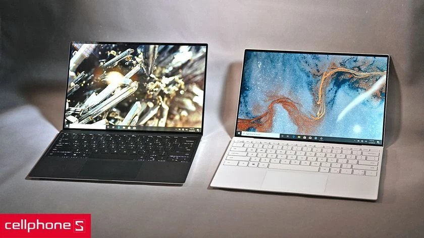 Một chiếc laptop mỏng nhẹ màu bạc đặt trên bàn làm việc cùng tài liệu, thích hợp cho doanh nhân.