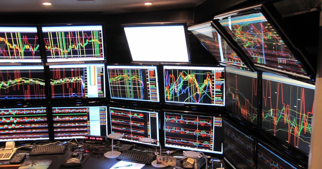 Setup bàn làm việc cỡ lớn chuyên nghiệp của một Trader với nhiều màn hình hiển thị dữ liệu
