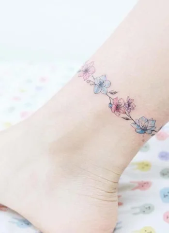 Hình xăm vòng hoa nhỏ nhắn quấn quanh cổ chân