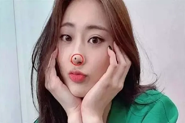 Người phụ nữ soi gương xem nốt ruồi